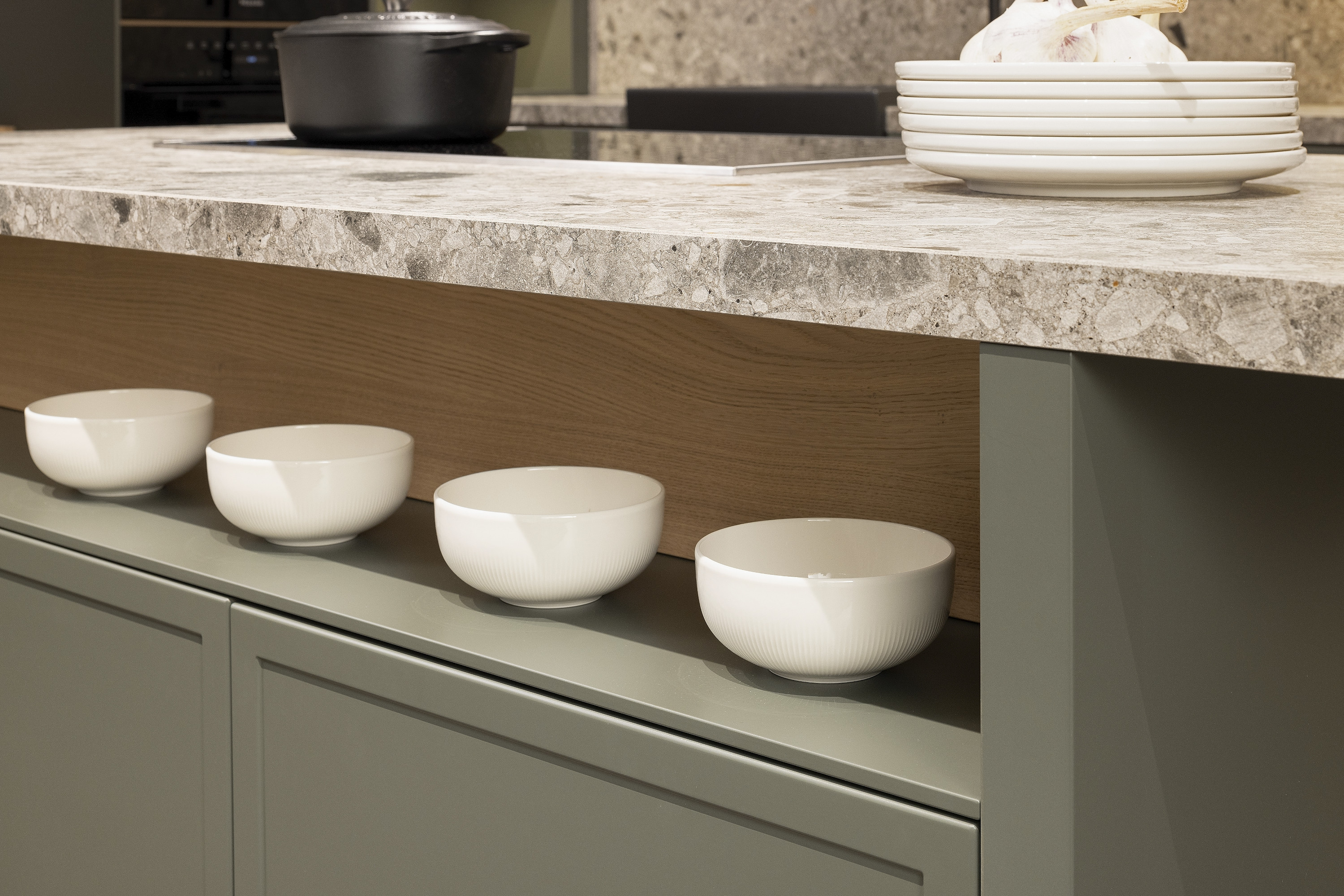 Vier weiße Schalen stehen nebeneinander unter einer Küchenarbeitsplatte.