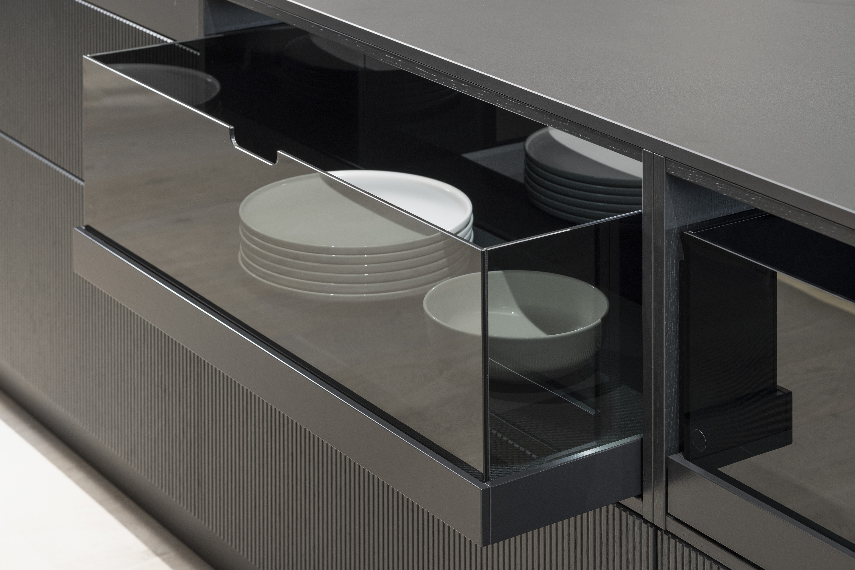 Schublade mit gestapelten weißen Tellern und Schalen in moderner Küche