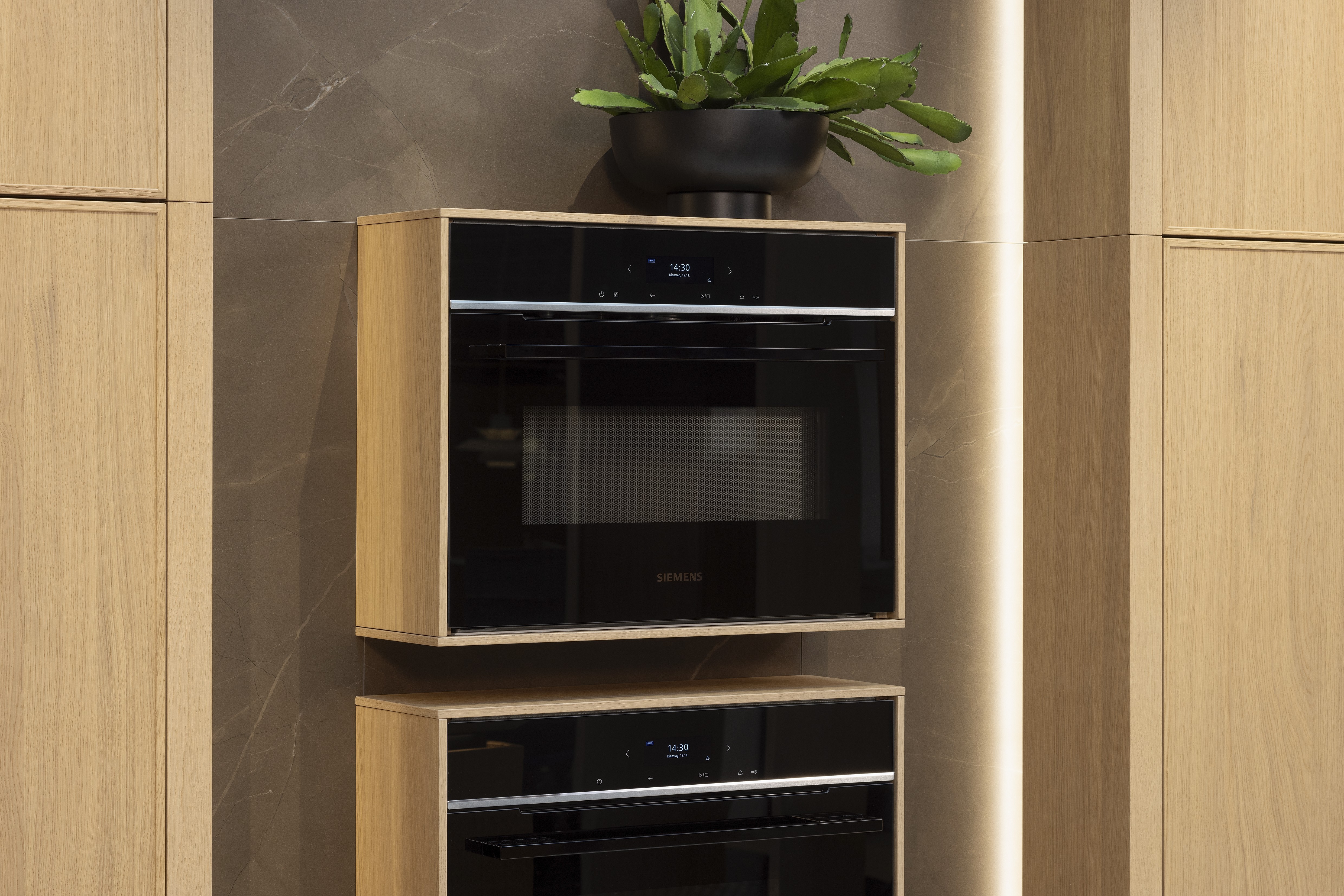 APL: Pulpis (Keramik) 25 mm Front: AV 6085-GL Eiche-elegant Echtholzfurnier (PURemission) Korpus: 2085 Designkorpus Feineiche-natur Griff: Kehlleiste 355 Schwarz matt Geräte: Siemens  Armatur: Gessi Spüle: ?  Features: neue Oberfläche Wiener Geflecht in Echtholzfurnier, Oberflächenmix, Waschbecken (Spülstein) in APL-Material, schwebende Arbeitsplatte durch Lichtleiste, APL abgekantet (schwebend), Backöfen in Wand eingekoffert, 3 Materialfarben.