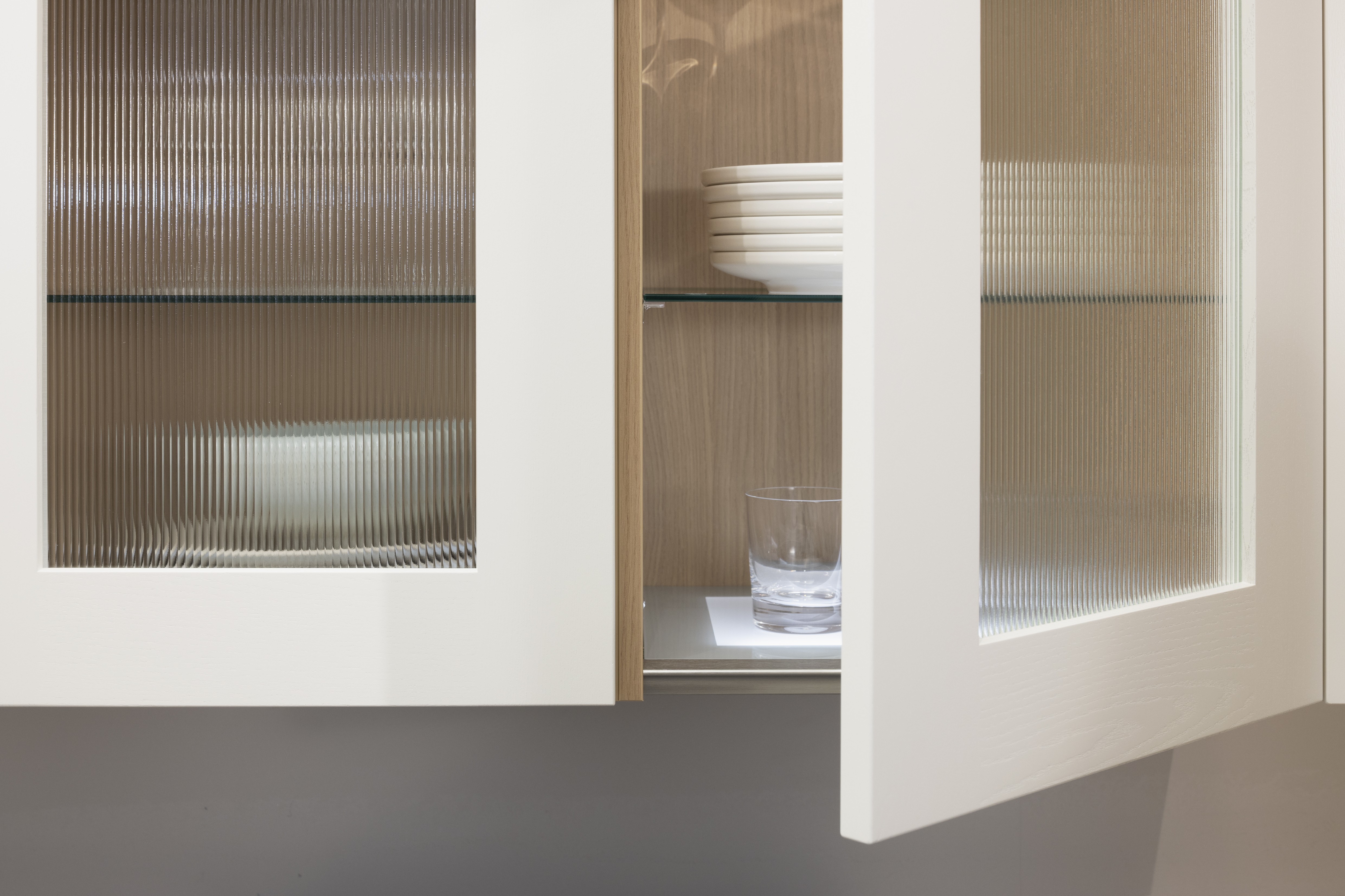 APL: 15 Kalkstein Repro 25 mm Front: AV 6055 Weiß Echtholz lackiert,  Front 2: AV 6082 Wildeiche-natur Korpus: 2085 Designkorpus Feineiche-natur Griff: 515 Metall Bronze-dunkel Geräte: Bosch  Armatur: Quooker Spüle: Systemceram   Features: Landhausküche modern, Echtholz RAL und NCS lackierbar, Riffelglasvitrine, Beleuchtung, schwebender Block, Echtholzfurnier lackiert kombiniert mit Echtholzfurnier, Fliesen, Korpus Echtholz Feineiche Natur, Griffe in Bronze. 