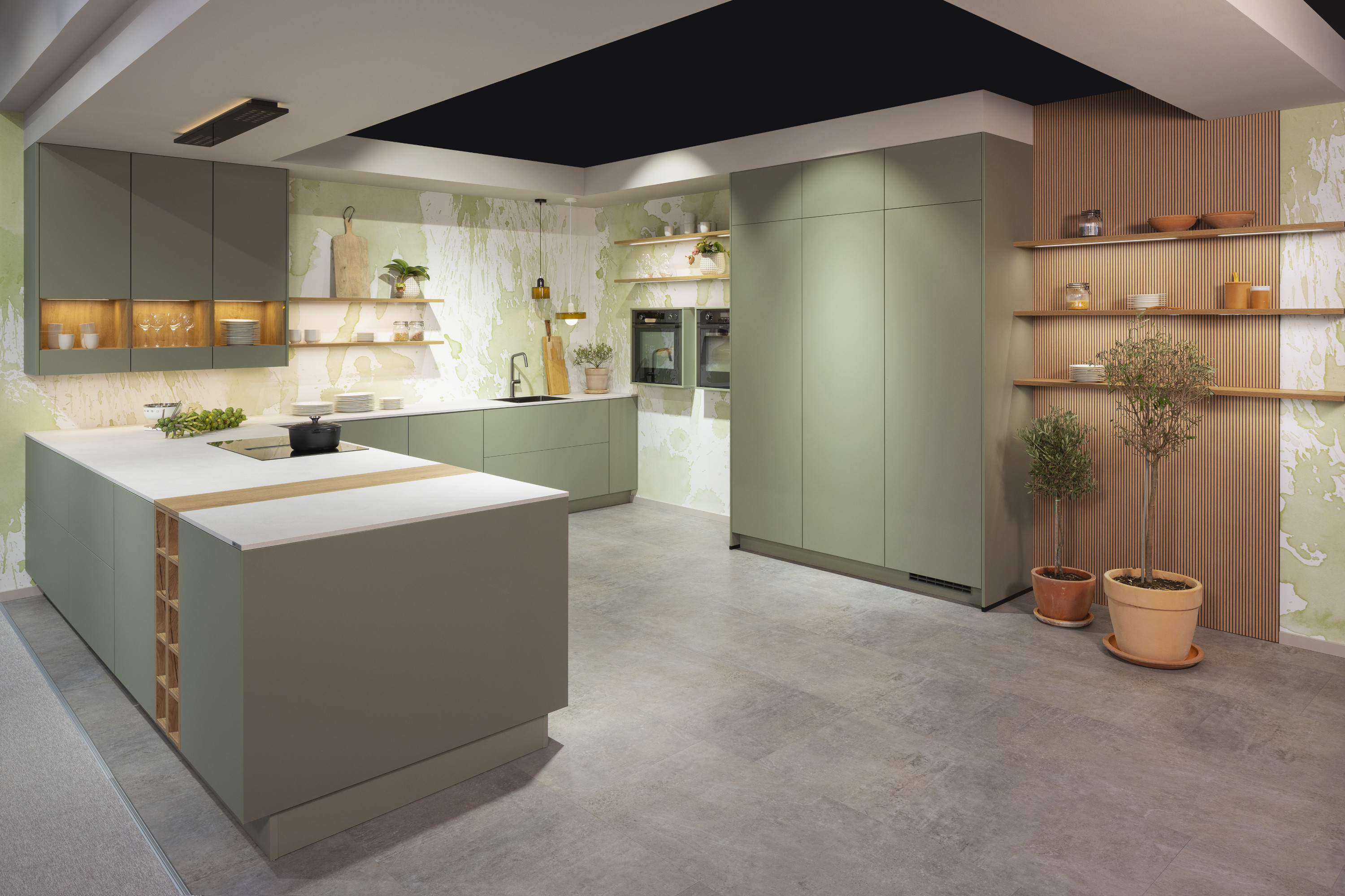 Moderne Küche mit grünen Schränken, Holzakzenten und Topfpflanzen auf offenen Regalen.