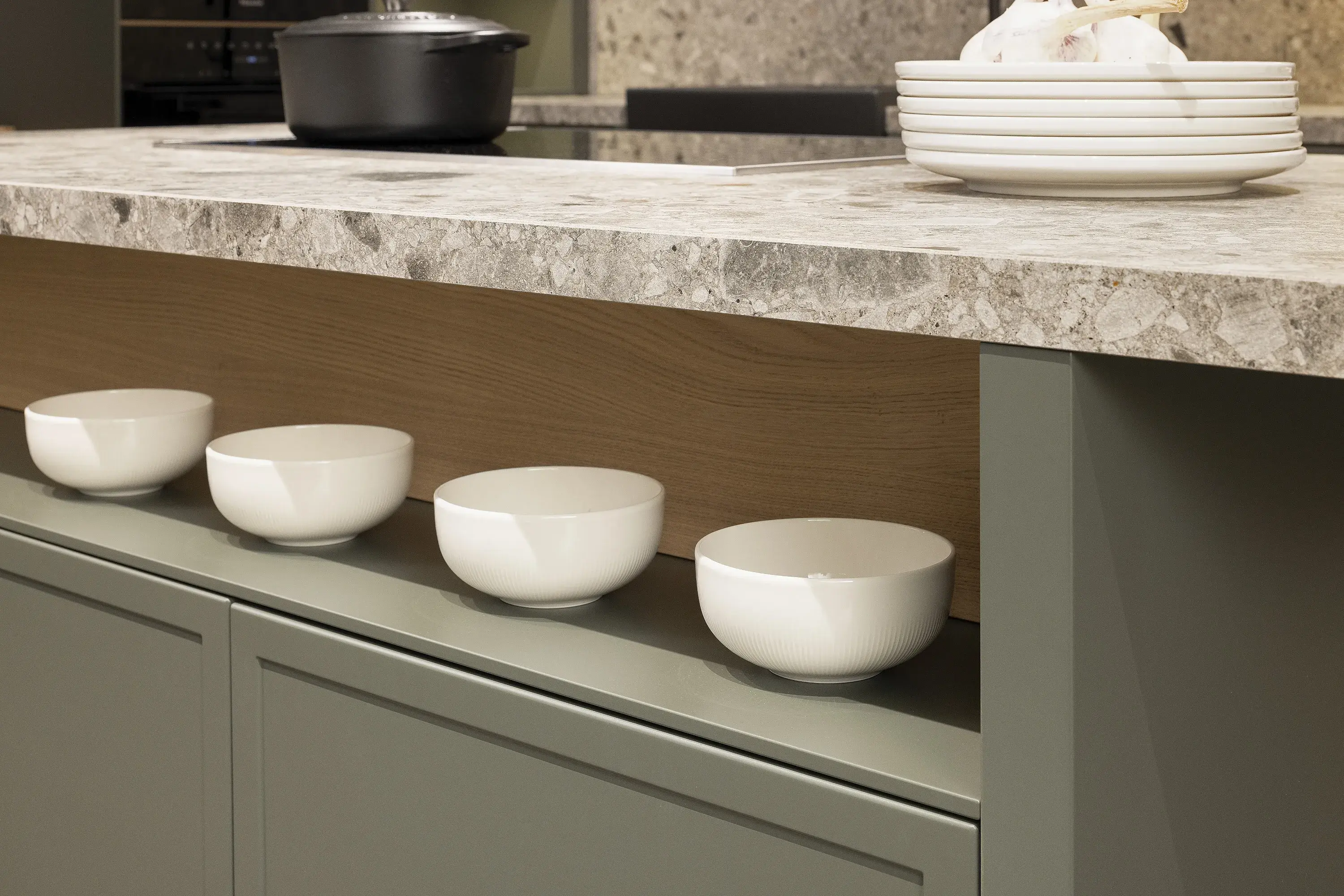 Vier weiße Schalen stehen nebeneinander unter einer Küchenarbeitsplatte.