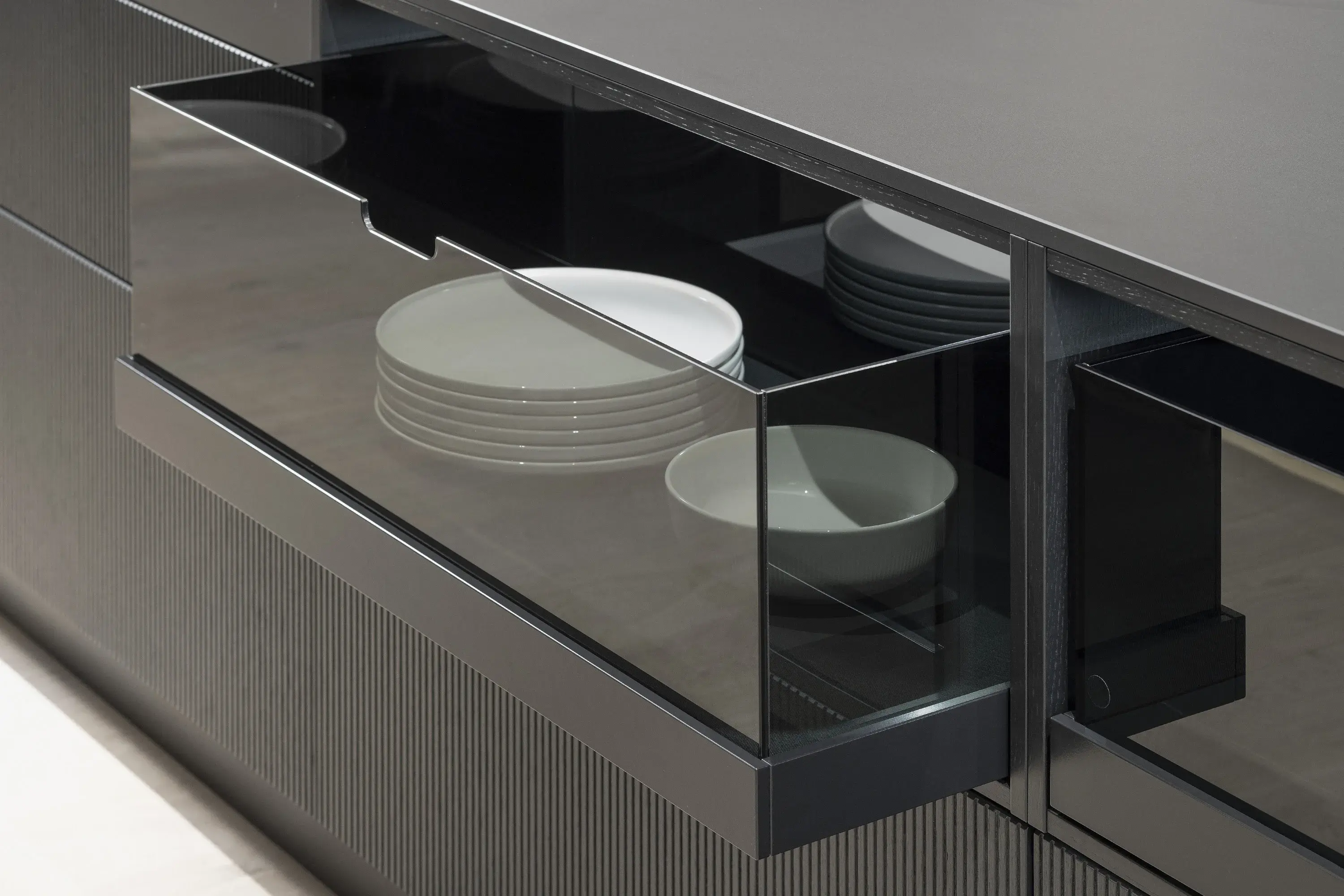 Schublade mit gestapelten weißen Tellern und Schalen in moderner Küche